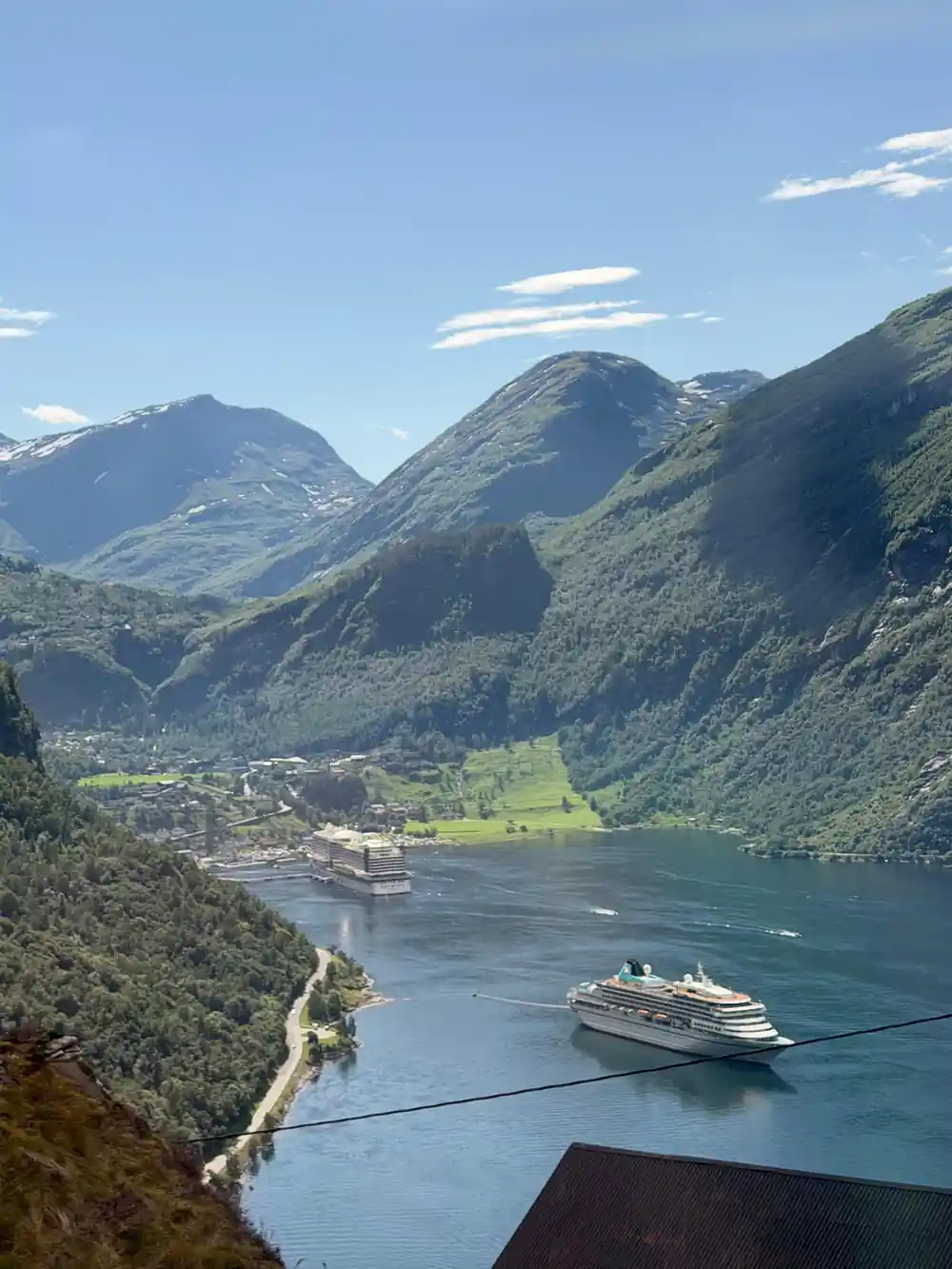 Cruise ship in narrow fjord surrounded by steep mountains