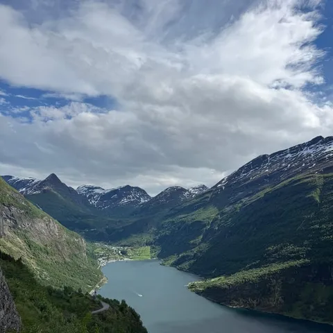 Fjord winding between green mountains under cloud