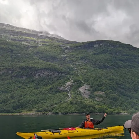 Kayakers in yellow and red kayaks on the fjord