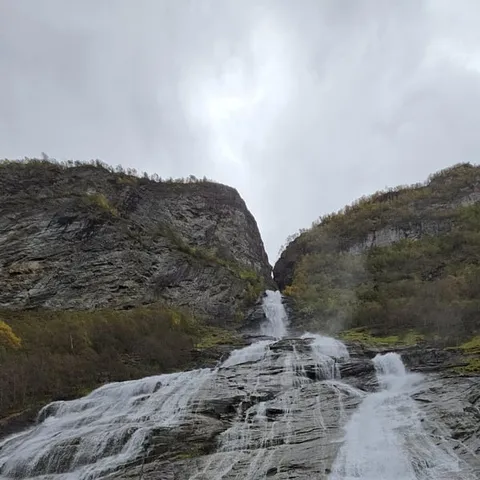 RIB passengers in survival suits photographing a waterfall