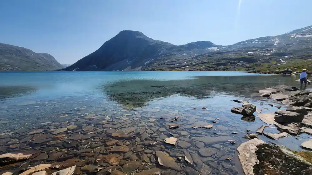 Rocky beach with turquoise water and mountain peak
