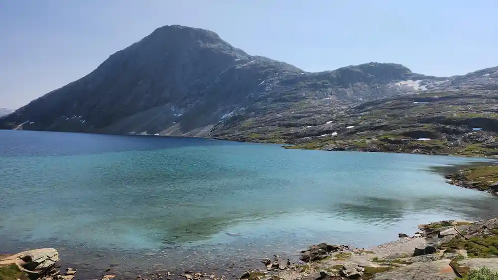 Turquoise lake with rocky shores and snow-capped peak