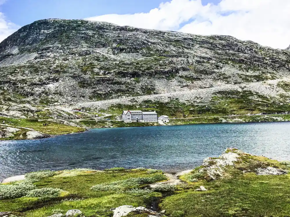 White lodge building beside turquoise lake under rocky mountain