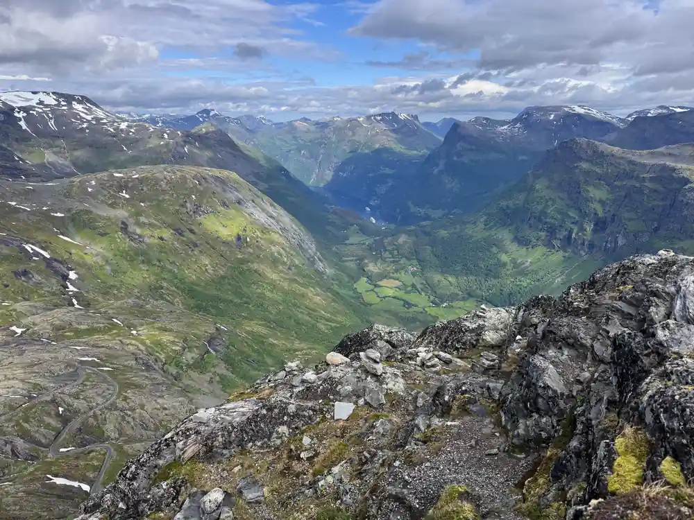 Wide green valley with mountains, glacier patches visible