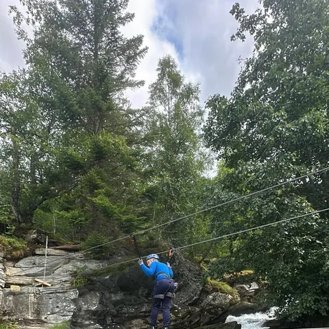 Rider on a zipline crossing above a river gorge